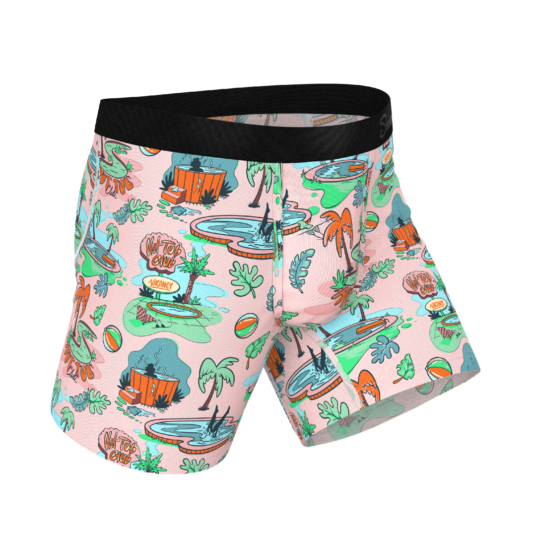 Colorful swim shorts with a tropical pattern on a white background